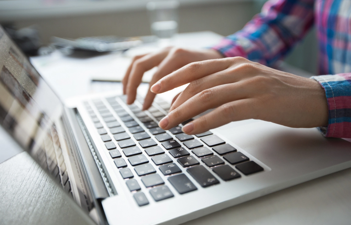 cropped-view-hands-typing-laptop 1.jpg